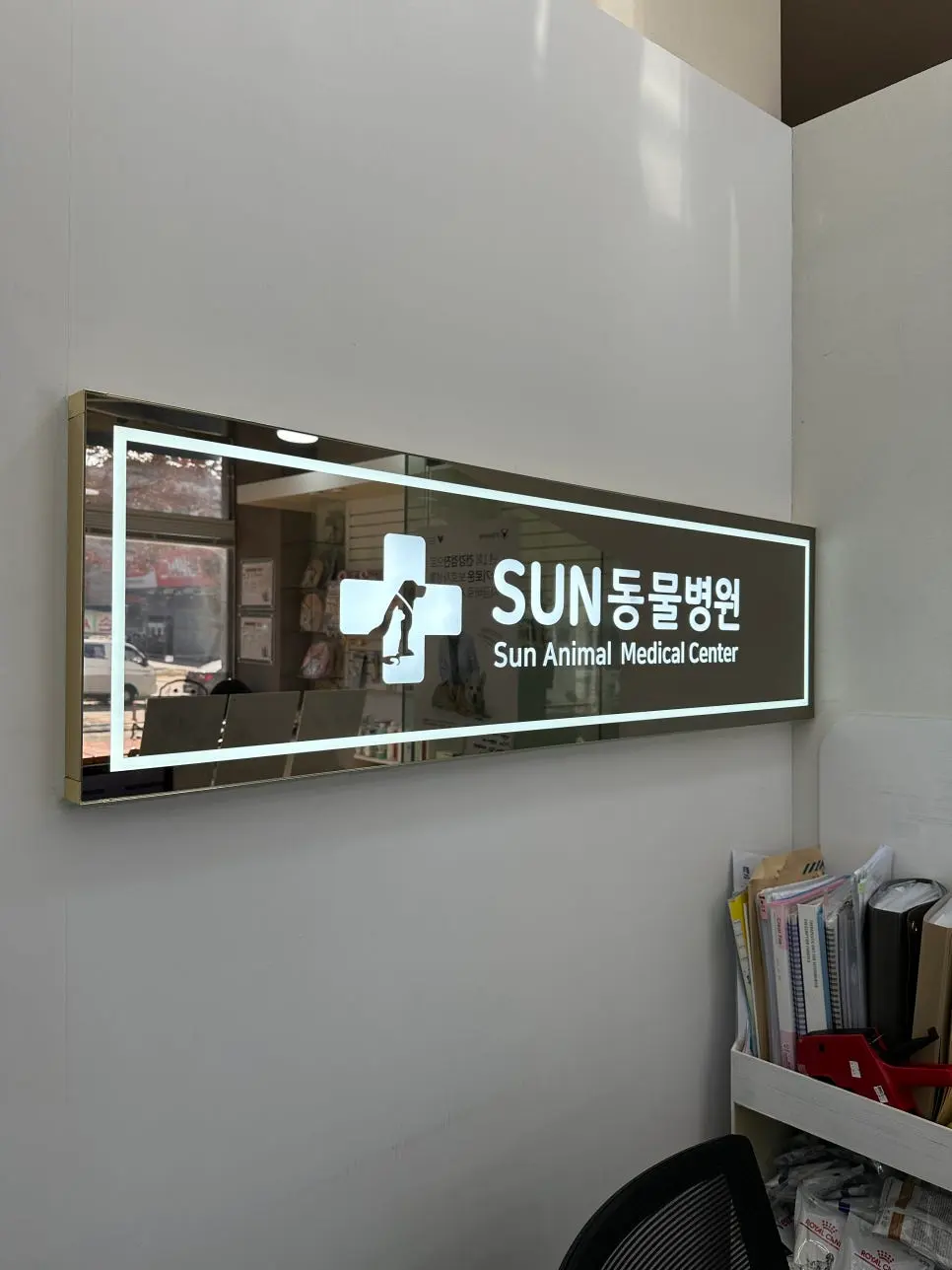 대기 공간 벽에 걸린 수원 썬동물병원 사인입니다.